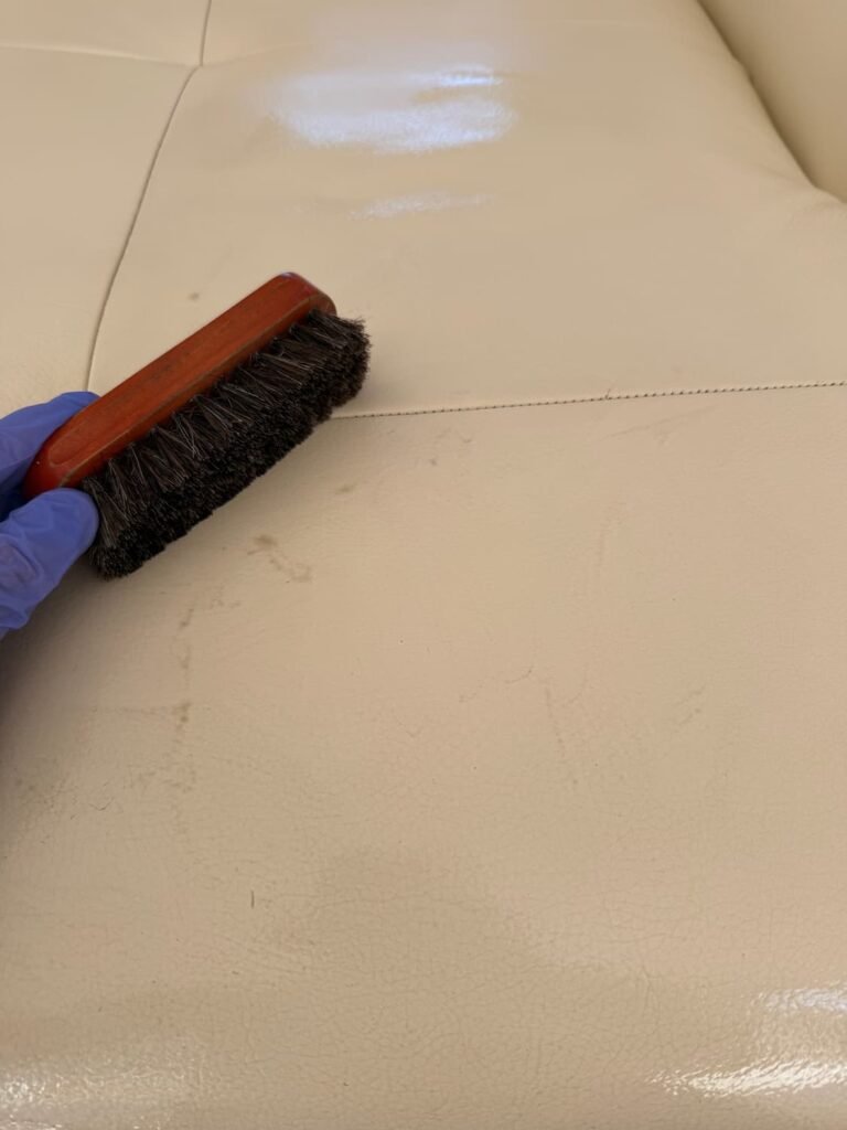 Brosse et salissures sur le cuir d’un canapé en cours de nettoyage — KeepClean83, service à Toulon dans le Var.